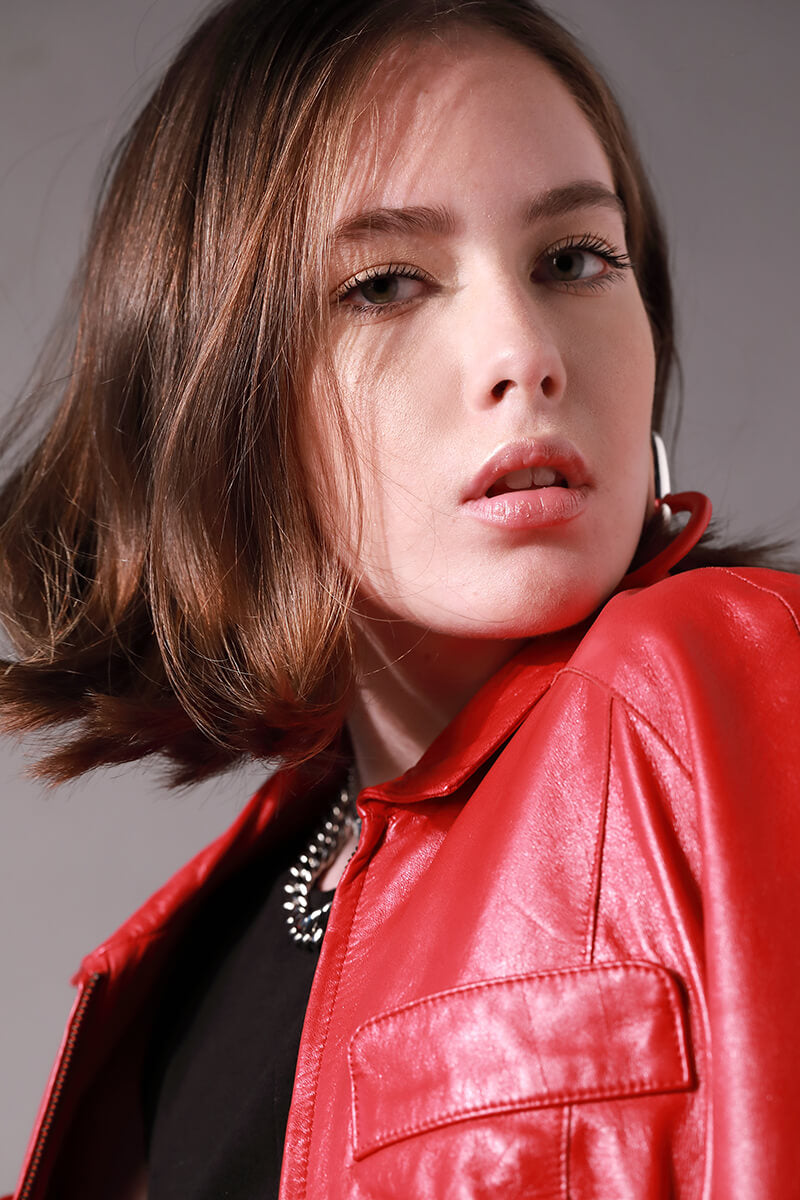 Model wearing a black top and red leather jacket accessorized with the Palma Necklace which is a thick chain made of Rhodium plated Stainless steel with box lock. 