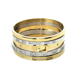 ANIMATED STACK: A luxurious stack of bangles featuring mixed metals in gold and silver tones. The set showcases a variety of designs including a buckle-inspired bangle with sparkling diamonds, a sleek gold bangle, and several minimalist silver bangles. The word "ARTIZAN" is subtly engraved on some of the bangles, adding a touch of elegance.