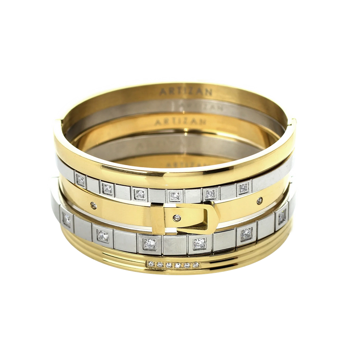 ANIMATED STACK: A luxurious stack of bangles featuring mixed metals in gold and silver tones. The set showcases a variety of designs including a buckle-inspired bangle with sparkling diamonds, a sleek gold bangle, and several minimalist silver bangles. The word "ARTIZAN" is subtly engraved on some of the bangles, adding a touch of elegance.