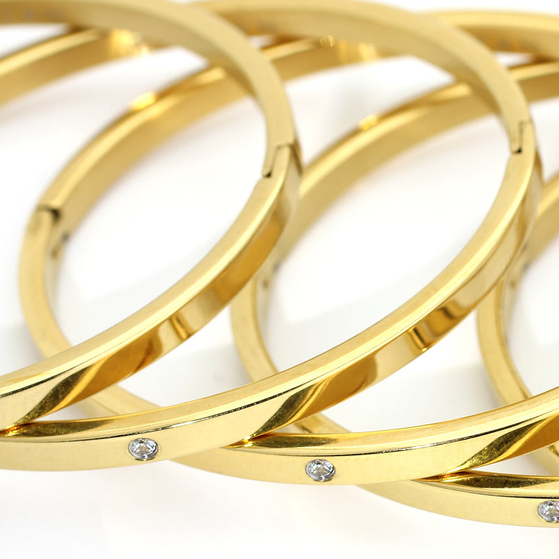 A stack of ONE SHINY BANGLE which is made of gold plated Stainless steel thin bangle with one encrusted tiny zirconia in the middle.