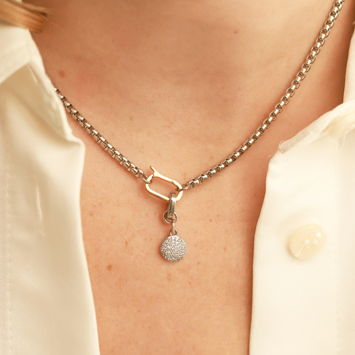 Model wearing a can opener necklace with the Dot Link Charm, which is a circle shaped diamond encrusted charm. ||| SILVER
