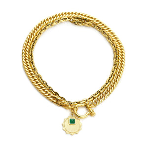 The Emerald Herradura, a two-piece gold layered necklace featuring a unique horseshoe pendant with an emerald accent.