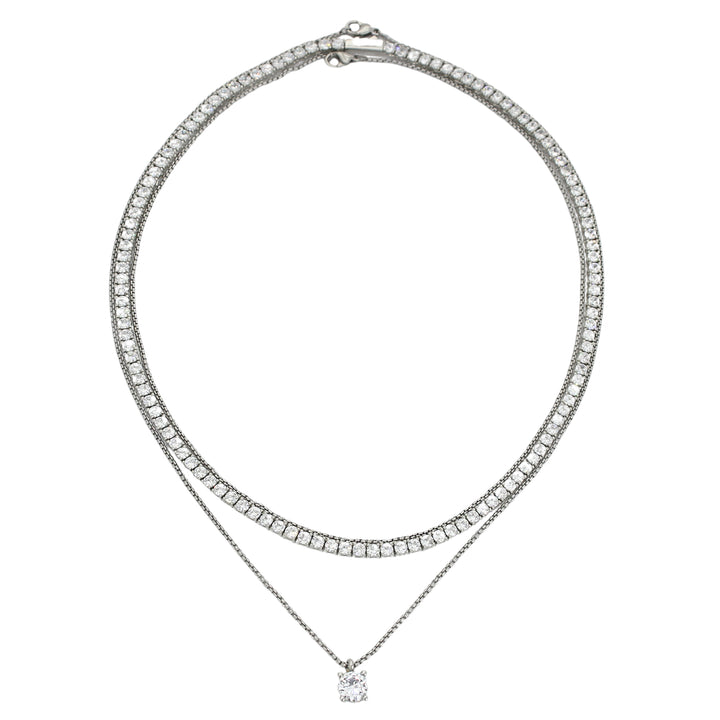 The TENNIS NECKLACE SET which is a 3 layered necklace set with 1mm Stainless steel Rhodium plated chain, a Rhodium-plated brass/cubic zirconia tennis necklace and 18" necklace with a Solitaire 1 ct zirconia pendant. 