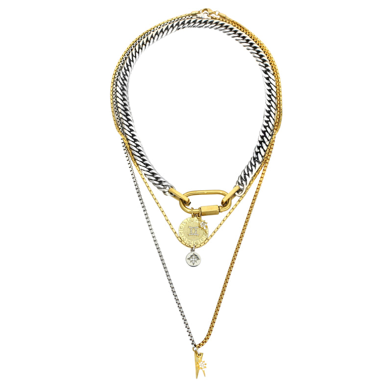 The Anne Zodiac Necklace which is a three pieces layered necklace set. Includes one silver chain with 18k gold plated carabiner and Gold Filled GEMINI Zodiac with Micro Pave Constellation charm, thin gold necklace with silver circle charm and another long necklace in half gold and silver with spike shaped charm and Gold Plated Micro Pave Studded Star.