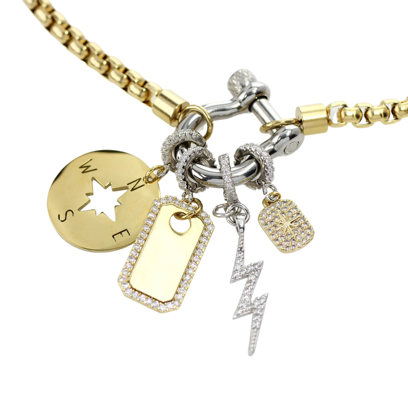 The Herradura Mix Necklace with gold chain and silver clasp. It comes with the north star, compass, plaque clip on and the LIGHTNING BOLT CLIP ON CHARM which is made of Pave Clip on Stainless steel 18k gold plated lighting bolt charm.
